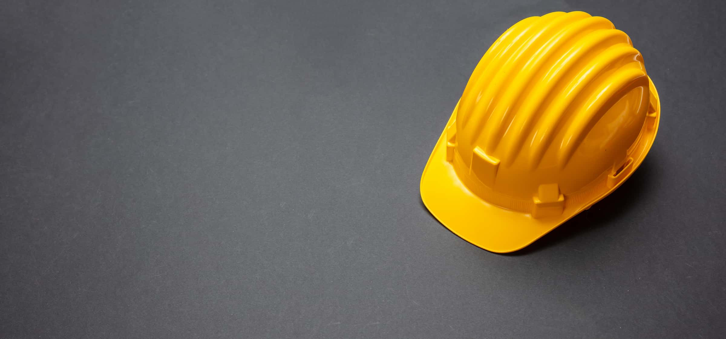 construction-project-safety-yellow-hard-hat-on-bla-NG9BPZS (1)